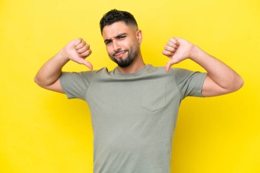 Sarı arka planda kendini beğenmiş, gururlu, yakışıklı genç bir Arap.