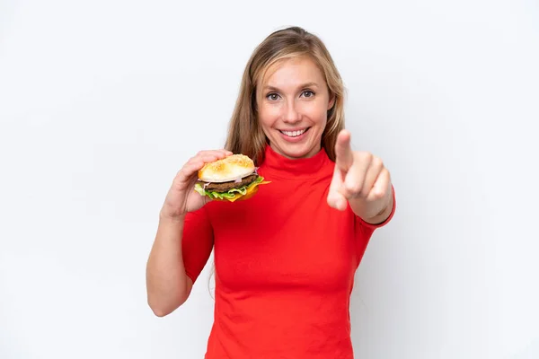 Młoda Blondynka Trzyma Hamburgera Białym Tle Wskazuje Palcem Ciebie Pewnym — Zdjęcie stockowe