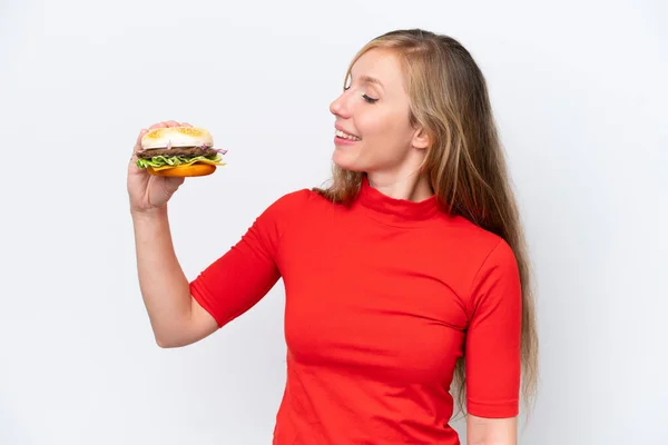 Młoda Blondynka Trzyma Hamburgera Białym Tle Szczęśliwym Wyrazem Twarzy — Zdjęcie stockowe