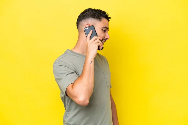 Young Arab Handsome Man Isolated Yellow Background Keeping Conversation Mobile — Zdjęcie stockowe