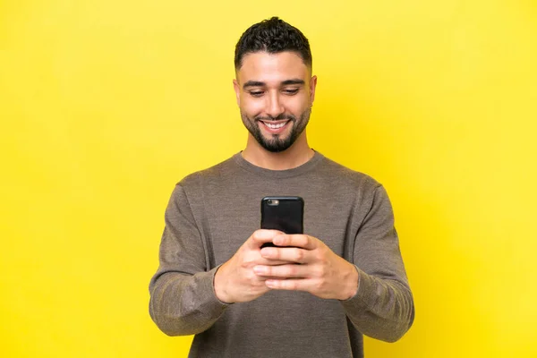 Νεαρός Άραβας Όμορφος Άνδρας Απομονωμένος Κίτρινο Φόντο Στέλνοντας Μήνυμα Κινητό — Φωτογραφία Αρχείου