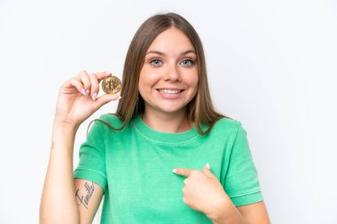Beyaz zemin üzerinde Bitcoin tutan güzel sarışın kadın. Şaşırtıcı bir yüz ifadesi var.