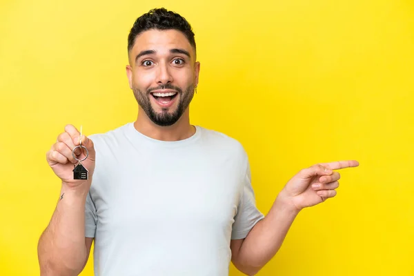 Mladý Arab Muž Drží Doma Klíče Izolované Žlutém Pozadí Překvapen — Stock fotografie