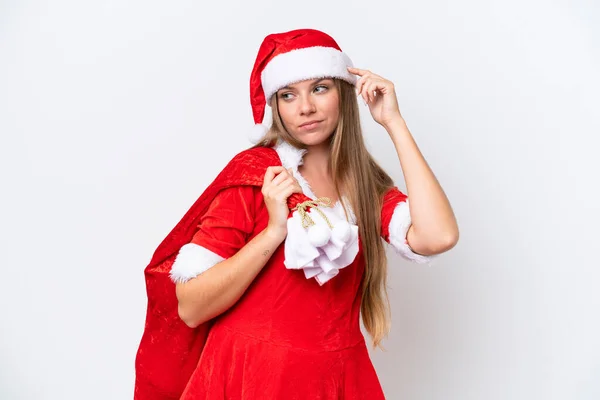 年轻的高加索女人穿着黑衣 拿着白色背景的圣诞礼物袋 满脸疑惑 满脸困惑 — 图库照片