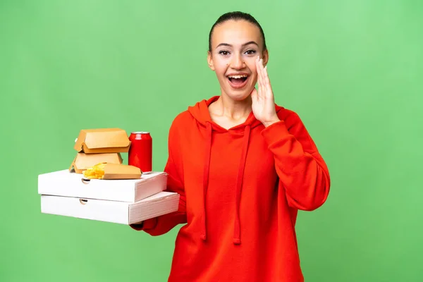 Young Arab Woman Holding Fast Food Isolated Background Shouting Mouth — Stock Photo, Image