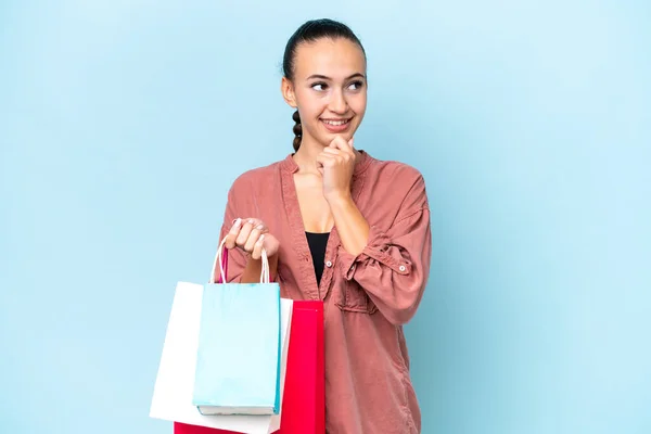 Young Arab Woman Isolated Blue Background Holding Shopping Bags Thinking — Stock Photo, Image
