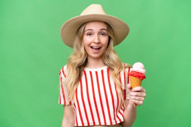 Kornet dondurması olan genç bir İngiliz kadın izole bir arka planda, şaşırmış ve şok olmuş bir yüz ifadesi var.