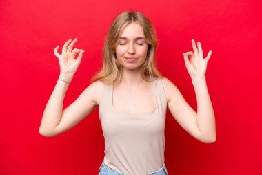 Zen pozunda kırmızı arka planda izole edilmiş genç İngiliz kadın.