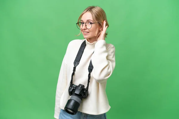 若い写真家英語の女性が耳に手を置くことによって何かを聞いて隔離された背景 — ストック写真