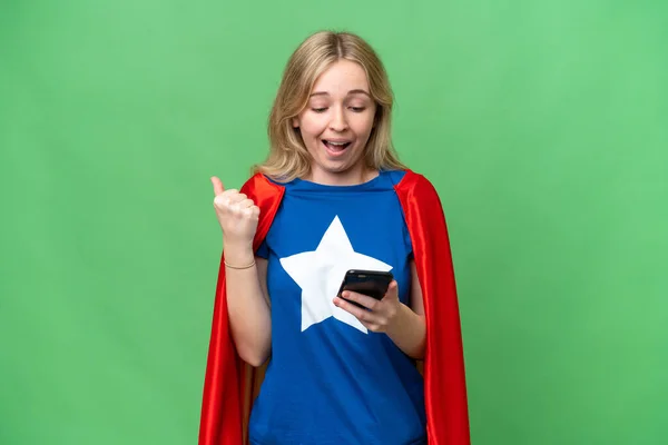 Super Hero English woman over isolated background surprised and sending a message
