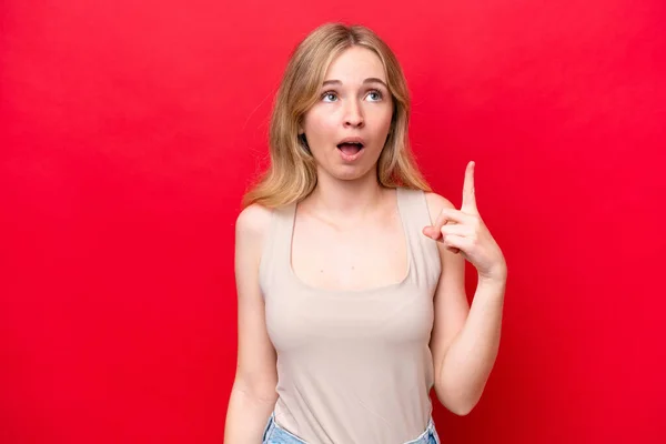 若い英語の女性は 指を指差すアイデアを考え 赤い背景に隔離された — ストック写真