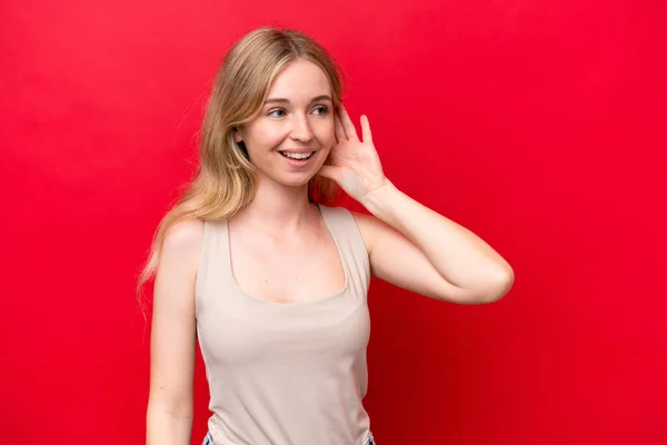 Young English Woman Isolated Red Background Listening Something Putting Hand — Stock Photo, Image