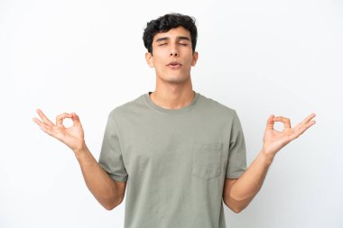 Young Argentinian man isolated on white background in zen pose