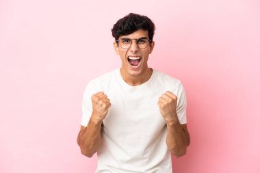 Pembe arka planda izole edilmiş genç Arjantinli adam kötü bir durum yüzünden hayal kırıklığına uğradı.