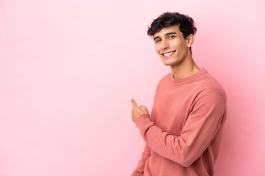 Arjantinli genç adam pembe arka planda izole edilmiş.