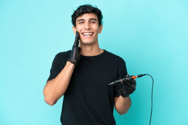 Dövme sanatçısı Arjantinli adam mavi arka planda şaşırmış ve şok olmuş bir yüz ifadesi ile izole edildi