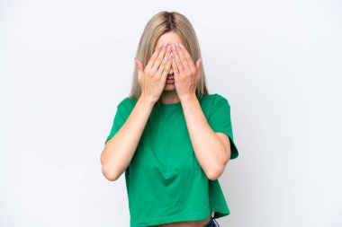 Pretty blonde woman isolated on white background covering eyes by hands