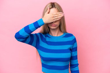 Pembe arka planda izole edilmiş güzel sarışın kadın gözlerini elleriyle kapatıyor. Bir şey görmek istemiyorum.