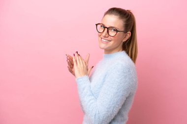 Pembe arka planda izole edilmiş genç beyaz kadın bir şeyler planlıyor.