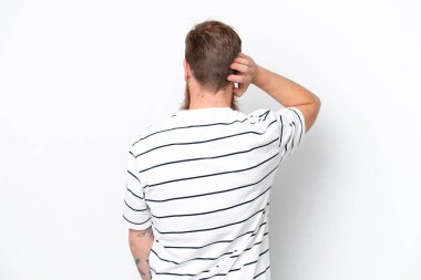 Kızıl saçlı, sakallı bir adam beyaz arka planda izole edilmiş ve düşünüyor.