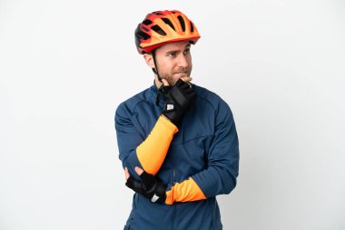 Beyaz arka planda izole edilmiş genç bisikletçi şüpheleri ve düşünceleri var.