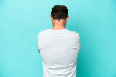 Orta yaşlı beyaz adam arka planda mavi arka planda izole edilmiş.