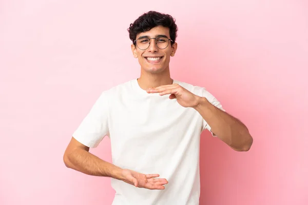 Jonge Argentijnse Man Geïsoleerd Roze Achtergrond Houden Copyspace Imaginaire Palm — Stockfoto
