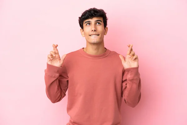 Jonge Argentijnse Man Geïsoleerd Roze Achtergrond Met Vingers Kruisen Wensen — Stockfoto