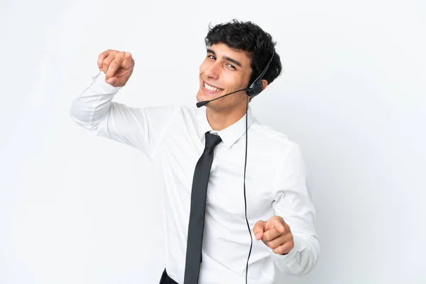 stock image Telemarketer man working with a headset isolated on white background points finger at you while smiling