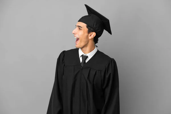 Junger Argentinischer Universitätsabsolvent Isoliert Auf Grauem Hintergrund Und Lacht Seitenlage — Stockfoto