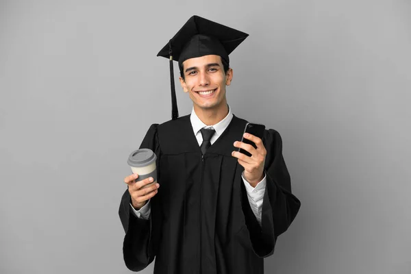 Νεαρός Αργεντινός Απόφοιτος Πανεπιστημίου Απομονωμένος Γκρι Φόντο Κρατώντας Καφέ Για — Φωτογραφία Αρχείου