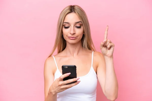 Pretty Blonde Woman Isolated Pink Background Using Mobile Phone Lifting — Stock Photo, Image