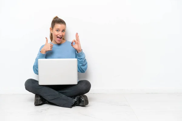 Junge Frau Mit Laptop Sitzt Auf Dem Boden Und Zeigt — Stockfoto