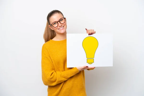 Young Caucasian Woman Isolated White Background Holding Placard Bulb Icon — Stock Photo, Image