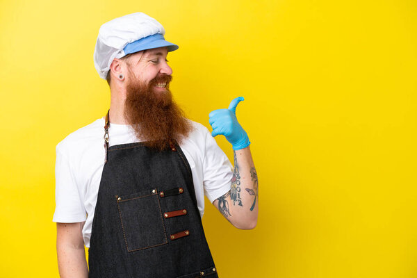 Рыболов в фартуке, изолированном на желтом фоне, указывая сбоку, чтобы представить продукт