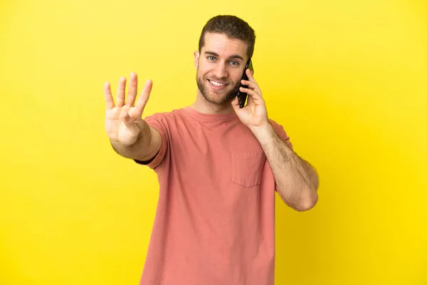 Handsome Blonde Man Using Mobile Phone Isolated Background Happy Counting — Stock Photo, Image