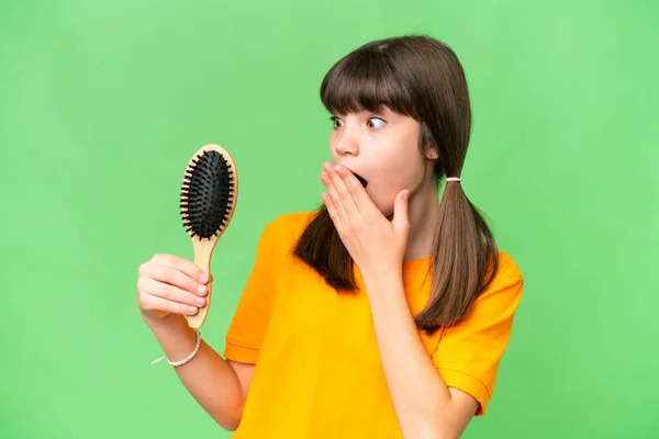 Little caucasian girl with hair comb over isolated background with surprise and shocked facial expression