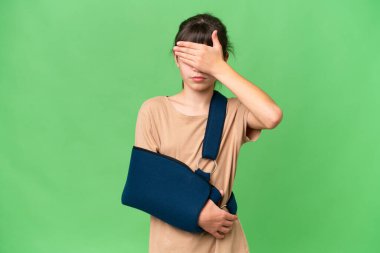 Kırık kollu beyaz bir kız ve izole edilmiş arka planda el ele tutuşan bir askı takıyor. Bir şey görmek istemiyorum.