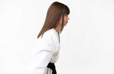 İzole edilmiş beyaz arka planda küçük beyaz kız karate yapıyor ve selam veriyor.