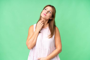 Orta yaşlı bir kadın soyutlanmış bir şekilde gülümserken yukarı bakıyor.