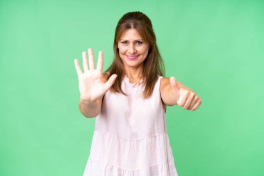 Soyutlanmış arka planda orta yaşlı kadın parmaklarıyla altı kişi sayıyor.