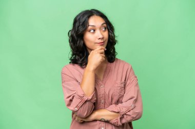 Arjantinli genç bir kadın izole edilmiş bir şekilde gülümseyerek yukarı bakıyor.