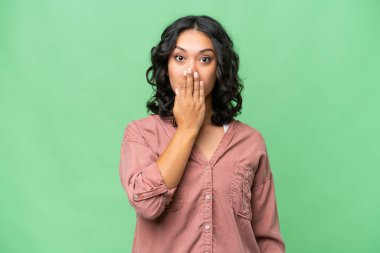 Arjantinli genç bir kadın izole edilmiş arka planda ağzını eliyle kapatıyor.