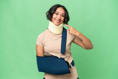 Arjantinli genç bir kadın boyunluk takıyor ve izole bir arkaplandan sarkıyor.