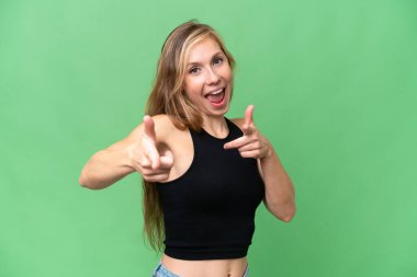 Soyutlanmış arka planda genç sarışın kadın öne bakıyor ve gülümsüyor.