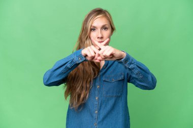 Sarışın genç bir kadın izole edilmiş arka planda bir hareketi durdurmak için el hareketi yapıyor.