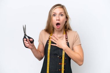 Beyaz arka planda izole edilmiş genç sarışın terzi kadın sağa bakarken şaşırmış ve şok olmuştu.