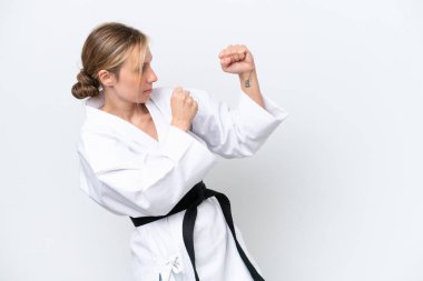 Beyaz arka planda karate yapan beyaz tenli genç kadın.