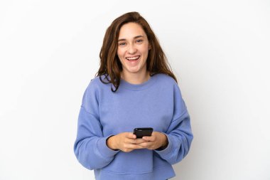 Beyaz arka planda izole genç beyaz kadın şaşırdı ve bir mesaj gönderiyor.