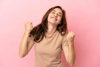 Pembe arka planda izole edilmiş beyaz bir kadın zaferi kutluyor.